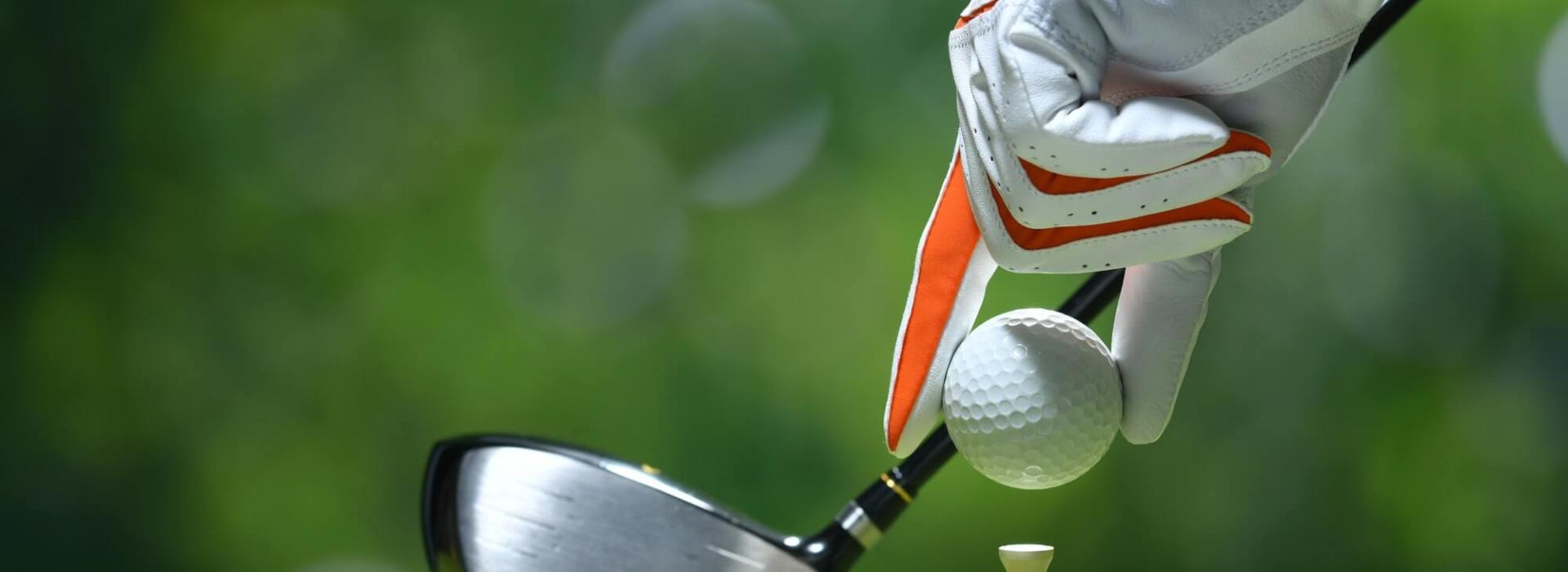 golfer placing golf ball on tee